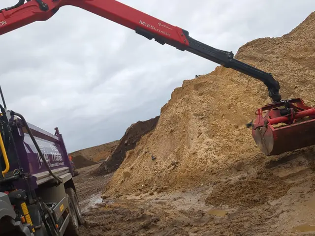 Grab lorry hydraulic arm loading soil on a Christchurch area job